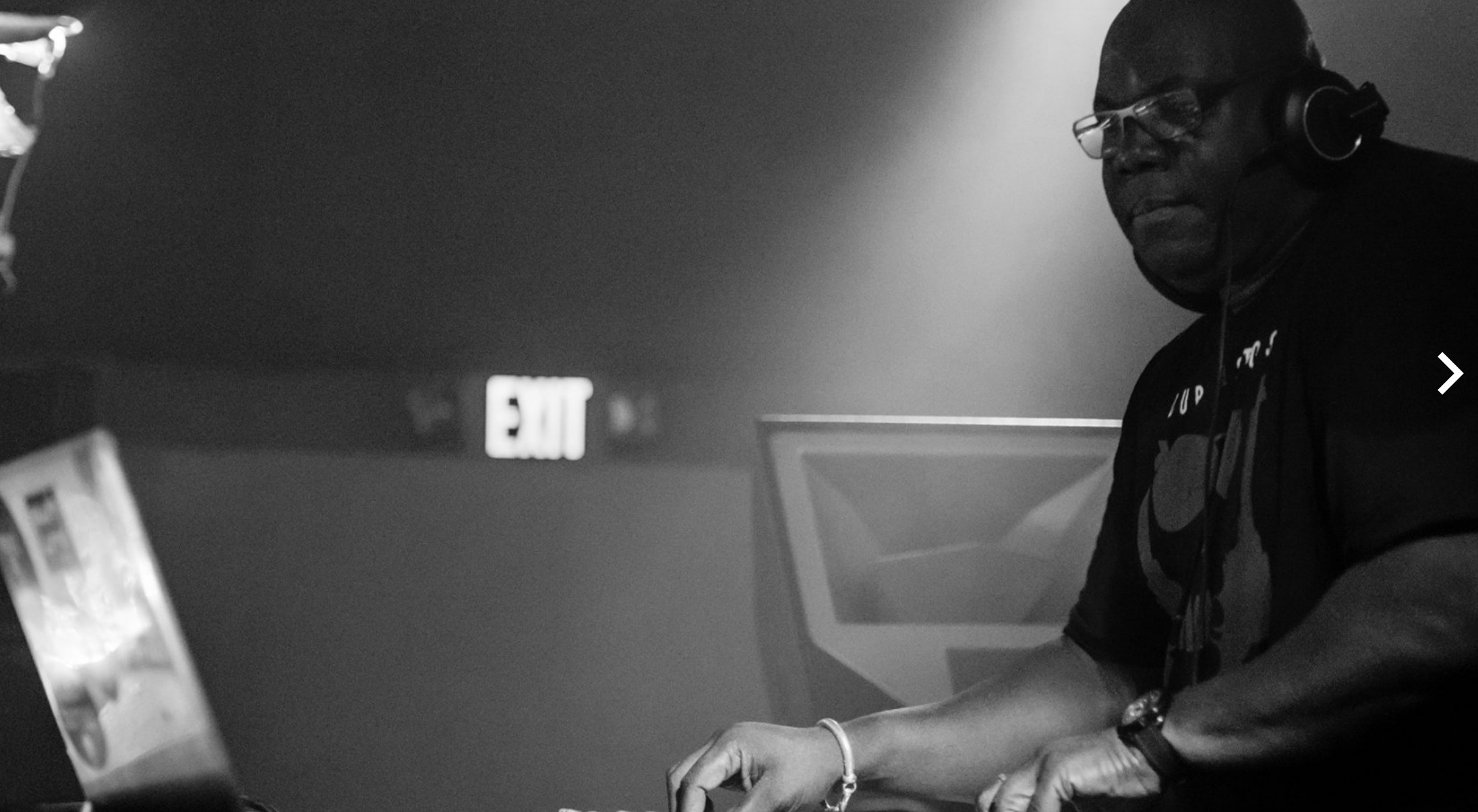 Black and white photo of Carl Cox performing.